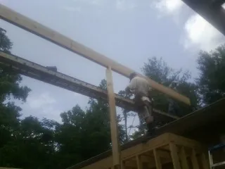 Carpenter setting a ridge beam over a new addition frame — Ice Dam Removal by Roofing Brothers in Hanoverton
