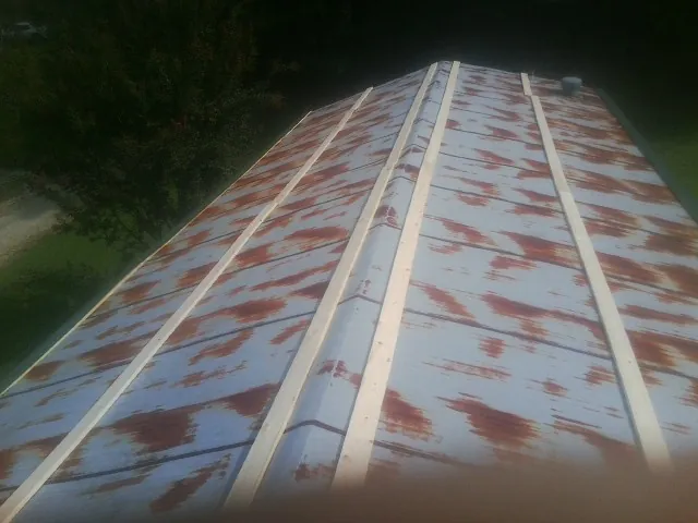 Rusted metal roof panels with new wood purlins before replacement — Storm Damage Roof Repair in Hanoverton by Roofing Brothers