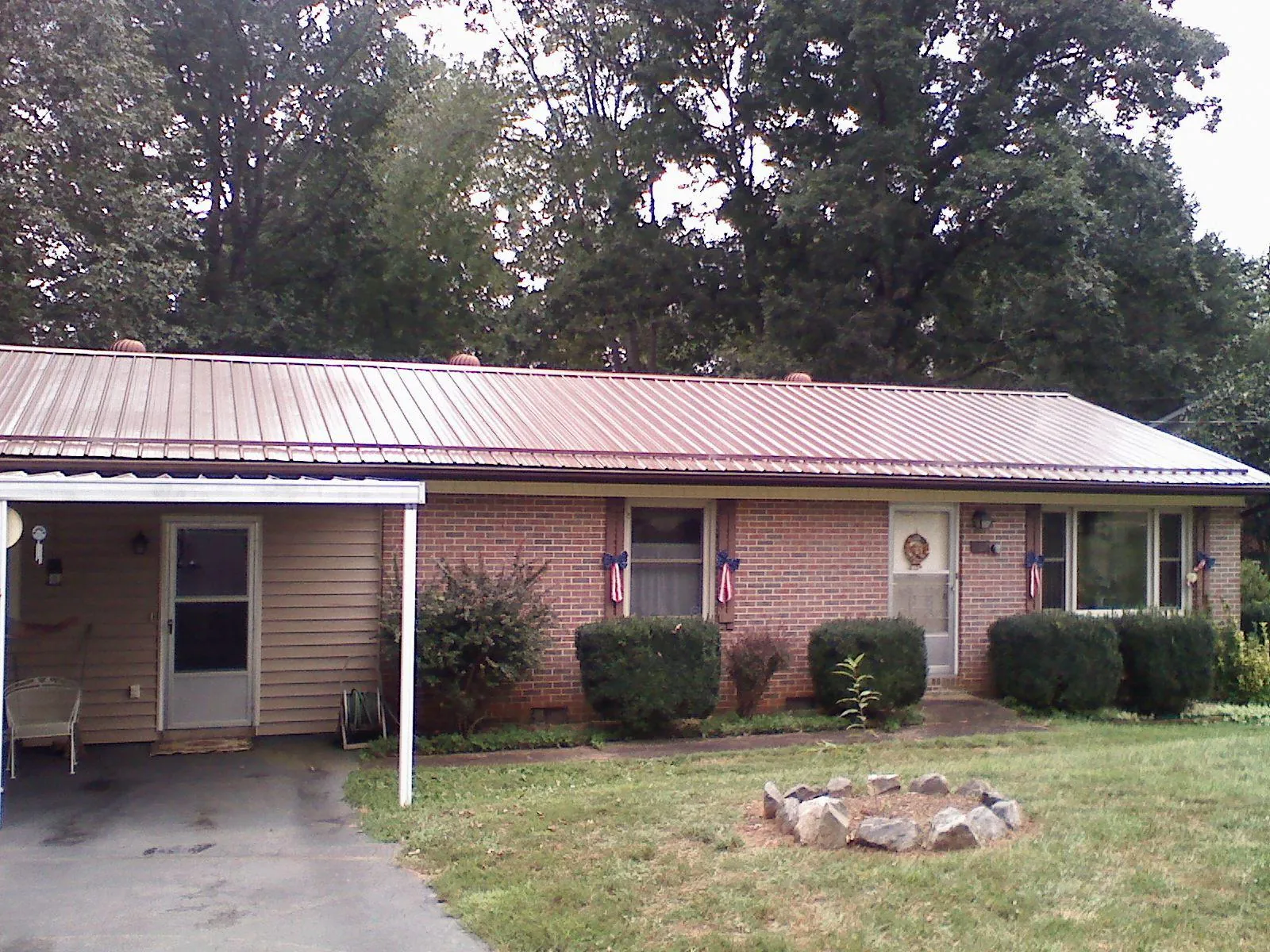 Bronze metal roof and carport on a brick ranch home — Roof Repair work by our crew in Hanoverton